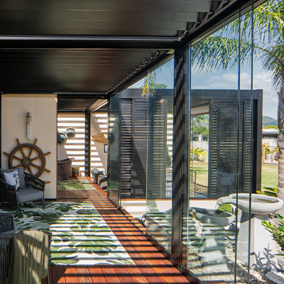 outdoor room with slats and glass panels to protect from weather