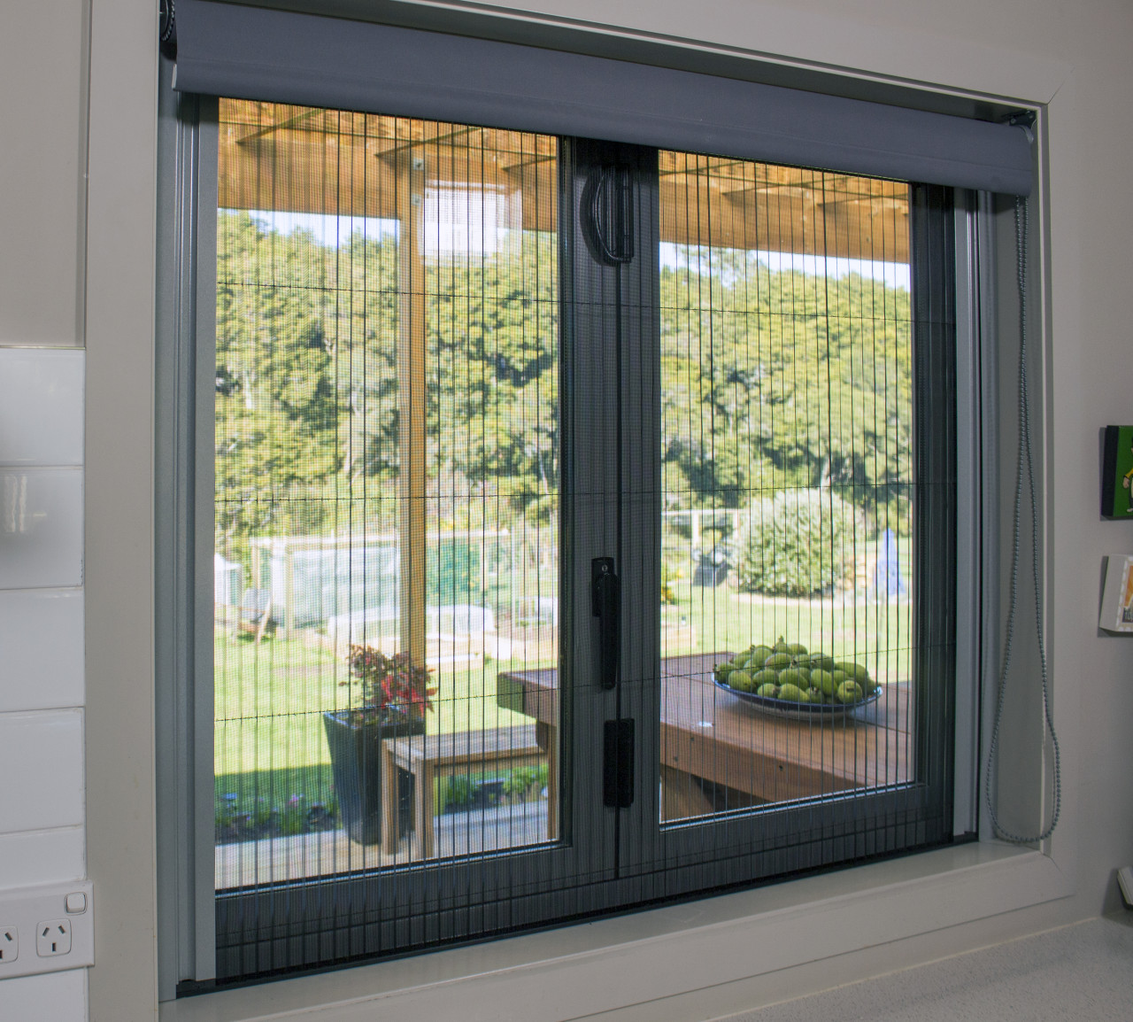 Kitchen window closed with horizontal Venette Window Screen in use